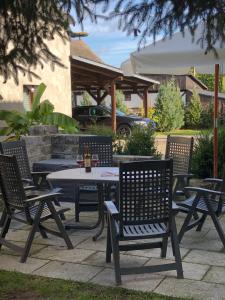 a picnic table with four chairs and a bottle of wine at Haff-Ostseeferienhausapartment Erdgeschoß in Mönkebude +48 photos