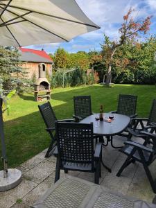 a patio with a table and chairs and an umbrella at Haff-Ostseeferienhaus Nebengebäude in Mönkebude +47 photos