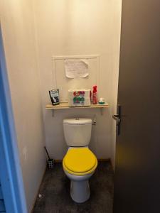 a toilet with a yellow seat in a bathroom at Escale Rennes in Rennes