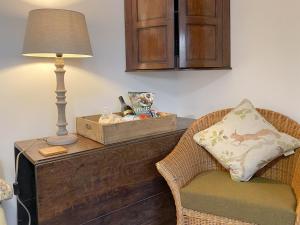a room with a table with a lamp and a chair at Smardale Cottage in Kirkby Stephen