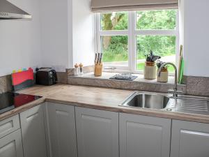 a kitchen counter with a sink and a window at Smardale Cottage in Kirkby Stephen +21 photos