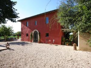 ein rotes Haus mit Kieseinfahrt davor in der Unterkunft Monaldesca in Spello