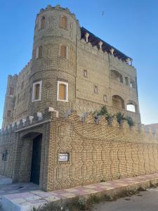 a large brick wall with a building behind it at Perle de Soliman Plage in Soliman