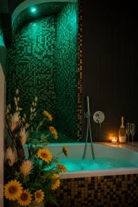 a bathroom with a tub with a green tiled shower at Vicolo delle Belle Suite in Terracina +22 photos