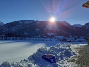 a pile of snow next to a body of water at Haus Peintner in Tannheim