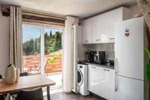 a kitchen with a refrigerator and a table and a window at Art House with Seaview & Jacuzzi by Konnect in Spartýlas