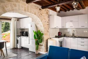 a kitchen with white cabinets and a blue couch at Art House with Seaview & Jacuzzi by Konnect in Spartýlas