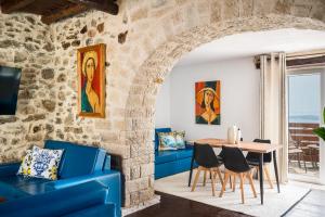 a living room with a blue couch and a table at Art House with Seaview & Jacuzzi by Konnect in Spartýlas