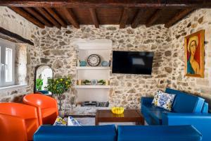 a living room with a blue couch and a tv at Art House with Seaview & Jacuzzi by Konnect in Spartýlas +10 photos