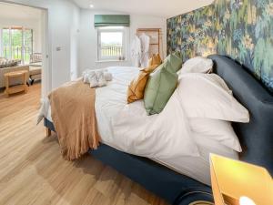 a bedroom with a large bed with pillows at The Rabbit Hole - Uk50123 in Bodelwyddan