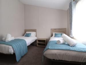 a bedroom with two beds with blue and white pillows at White House in St Asaph