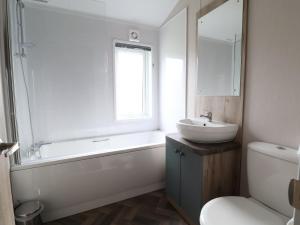 a bathroom with a sink and a tub and a toilet at White House in St Asaph