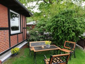 a patio with a table and two benches and a bush at Bungalow Hartmann in Lüssow