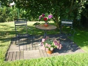 two chairs and a table with flowers on it at Bungalow Hartmann in Lüssow