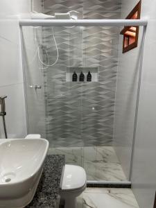 a bathroom with a shower with a toilet and a sink at Apartamento aconchegante em Irecê in Irecê