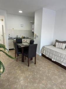 a room with a table and chairs and a bed at Altos de Centro Chivilcoy 7 in Chivilcoy