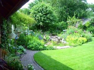 a garden with green grass and a walk way at Ferienwohnung Diena - Unterkunft mit toller Ausstattung und zwei Terrassen in Tarp