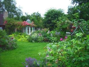 a garden with flowers and plants in front of a house at Ferienwohnung Diena - Unterkunft mit toller Ausstattung und zwei Terrassen in Tarp