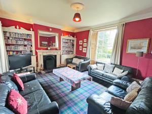 a living room with leather couches and a tv at Abbott's Farm in Horbling