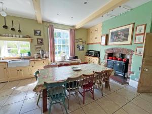 a kitchen with a table and chairs and a fireplace at Abbott's Farm in Horbling