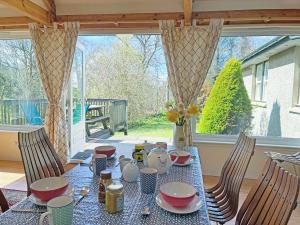 a table with plates and cups on top of it at Garrique Cottage in Kippen