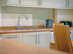 a kitchen with white cabinets and a sink at Easter Caiplich - Uk30263 in Cray +9 photos
