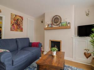 a living room with a blue couch and a fireplace at 6 Bedford Place in Bridport