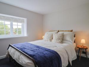 a white bedroom with a large bed and a window at 6 Bedford Place in Bridport