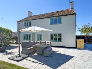a patio with a table and an umbrella at Hill House - Uk49727 in King's Lynn