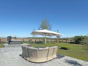 a patio with an umbrella and chairs and a table at Hill House - Uk49727 in King's Lynn