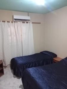 a hotel room with two beds and a window at K&M descanso y excursiones in Fiambalá