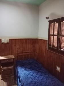 a bedroom with a bed and a desk and a window at K&M descanso y excursiones in Fiambalá +2 photos