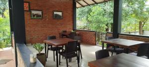 a patio with tables and chairs and a brick wall at Voyager's Villa in Habarana