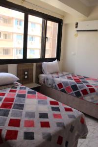 a bedroom with two beds and a window at فندق النادي in Aswan