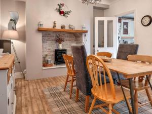 a kitchen and dining room with a table and chairs at Sonny Cottage in Glanamman