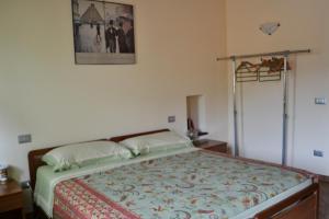 VasiaにあるCasa Rossanaのベッドルーム1室(ベッド1台付)が備わります。壁に絵が飾られています。