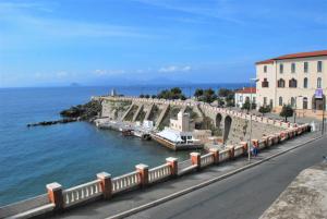 a road next to a body of water next to a building at Borgo Mare in Piombino