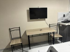 a room with a table and two chairs and a tv at Aleka Apartments in Kos