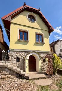 a small yellow house with a brown door at Búda u Totevú in Skalica