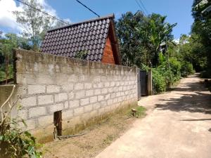 a brick wall next to a dirt road at Secret Garden Ella Cabana & Stay in Ella