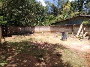 a backyard with a brick wall and a fence at Secret Garden Ella Cabana & Stay in Ella