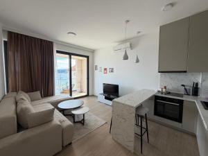 a kitchen and living room with a couch and a table at Zenith Lux Apartment Beachfront & Parking in Bijela