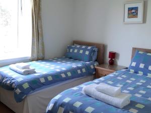 a bedroom with two twin beds and a window at Degnish Farmhouse - Swwu in Kilmelfort