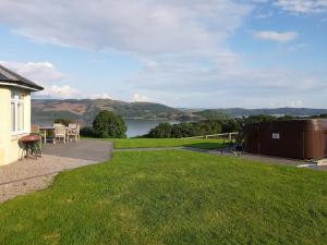 a backyard with a view of a lake and a house at Degnish Farmhouse - Swwu in Kilmelfort +10 photos