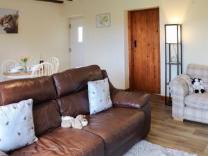 a brown leather couch with two teddy bears on it at Towy Cottage - Uk49589 in Llansawel