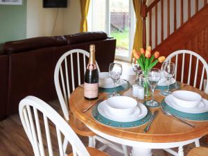a dining room table with a bottle of wine on it at Towy Cottage - Uk49589 in Llansawel