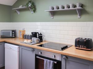 a kitchen with a counter top with a stove top oven at Towy Cottage - Uk49589 in Llansawel +6 photos