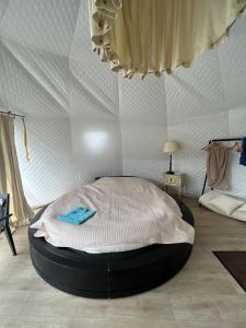 a large bed in a room with a wall at Ozols in Vecpiebalga