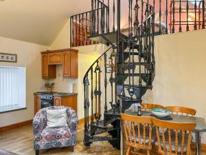 a kitchen with a spiral staircase and a table and chairs at Ploughman's Rest - Uk51336 in Peebles