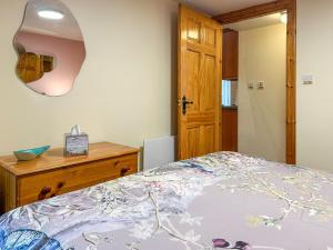 a bedroom with a bed and a dresser and a mirror at Ploughman's Rest - Uk51336 in Peebles +3 photos